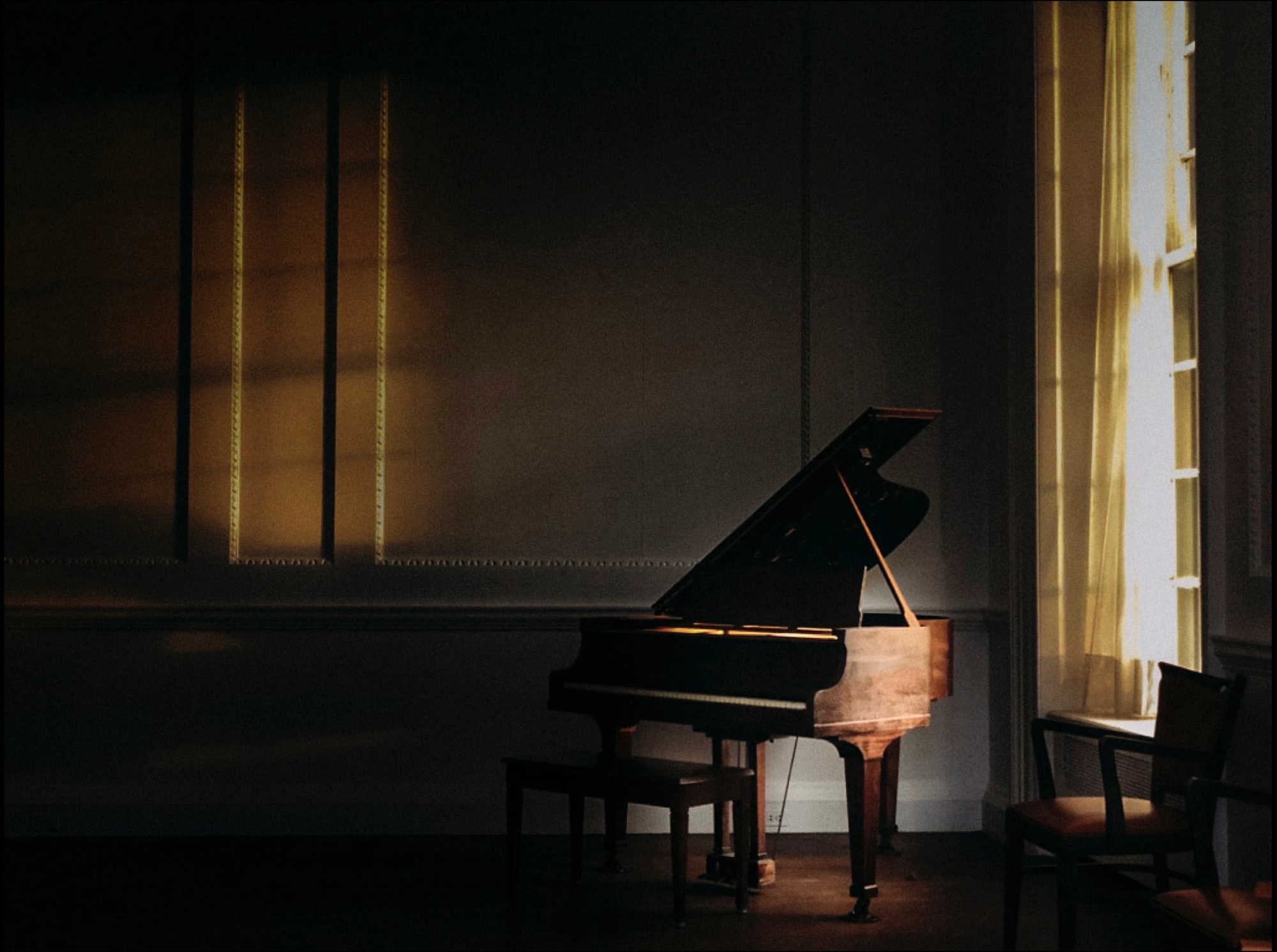 Window light over a grand piano